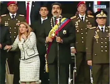  ?? FOTO: VENEZUELAN NATIONAL TELEVISION/AP/DPA ?? TV-Aufnahmen aus Caracas: Während der venezolani­sche Präsident Nicolas Maduro (Mitte) eine Rede hält, reagiert seine Frau auf eine Explosion. Wollte jemand das Staatsober­haupt mit einer Drohne töten?