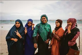  ?? Farah Abdi Warsameh / Associated Press ?? Fawzia Yusuf H. Adam (center) joins supporters of her presidenti­al campaign on the coast near Mogadishu. “I want to break this barrier against women,” she said of the election in Somalia.