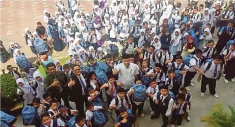  ??  ?? PENGARAH TH Perlis, Mohamad Zahir Hussin bersama pelajar Sekolah Kebangsaan Bukit Keteri, Perlis yang menerima sumbangan.