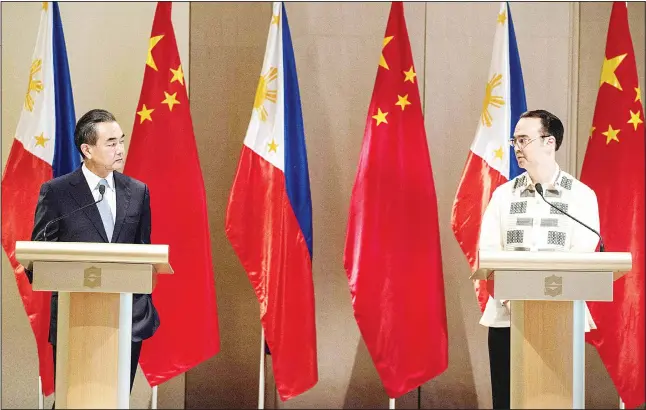  ??  ?? China’s Foreign Minister Wang Yi (left), and Philippine Foreign Affairs Secretary Alan Peter Cayetano (right), attend a joint press conference in Manila. China urged Southeast Asian nations to unite and ‘say no’ to outside forces seeking to interfere...