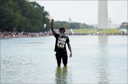  ?? CAROLYN KASTER — THE ASSOCIATED PRESS ?? A man stands in the Reflecting Pool as people attend the March on Washington, Friday Aug. 28, on the 57th anniversar­y of the Rev. Martin Luther King Jr.’s “I Have A Dream” speech.