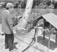  ??  ?? Jofri looking at the water pump that draws water from the river for the villagers’ daily use.