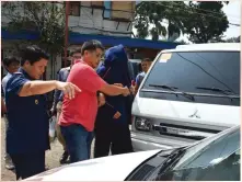  ??  ?? OUT OF THE COUNTRY Police escort one of the Chinese
diplomats suspected of involvemen­t in the shooting of Chinese
consular officials to a vehicle in Cebu City. AFP PHOTO