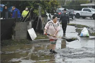  ?? AP photo ?? A woman removes debris from floods during a rain storm on Monday, in San Diego.