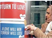  ?? FOTO: DPA ?? Eine Frau befestigt Plakate an der neuseeländ­ischen Botschaft in London.