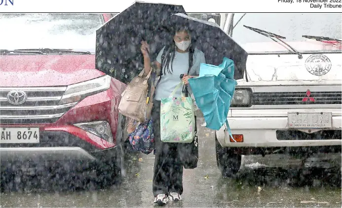  ?? PhotograPh by analy labor for the daily tribune @tribunephl_ana ?? teaCher uses multiple umbrellas to shield herself from heavy rain on thursday. PagaSa said at least two or three typhoons are expected to hit the country before this month ends.