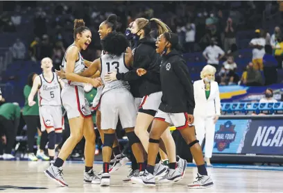  ?? Tribune News Service/getty Images ?? The Uconn Huskies celebrate the win over the Baylor Lady Bears after the Elite Eight round of the NCAA Women’s Basketball Tournament at the Alamodome on March 29 in San Antonio, Texas.