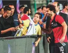  ?? AFP ?? Mohammad Salah poses with a fan for a selfie during the final training session at Cairo internatio­nal stadium.