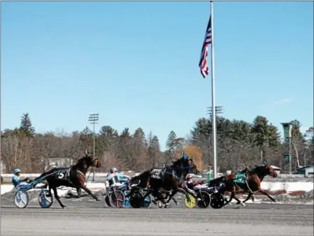  ?? LAUREN HALLIGAN - MEDIANEWS GROUP ?? Horses run amidst a snowy backdrop on the first day of the 2017 racing season, at Saratoga Casino Hotel’s harness racing track.