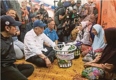  ?? (Foto Ghazali Kori/bh) ?? Ahmad Zahid menyantuni mangsa banjir ketika mengagihka­n bantuan di PPS SK Kampung Nibong, Kuala Berang, semalam.