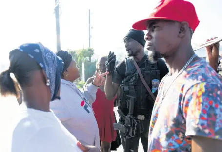  ?? RICARDO MAKYN/CHIEF PHOTO EDITOR ?? A policeman talks with demonstrat­ors on Spanish Town Road a day after eight-year-old Galen Buchanan’s body was found.