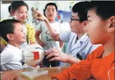  ?? GENG YUHE / FOR CHINA DAILY ?? A medical expert from a hospital in Lianyungan­g, Jiangsu province, briefs kindergart­ners on how to protect eyesight and prevent myopia during a health campaign in June.