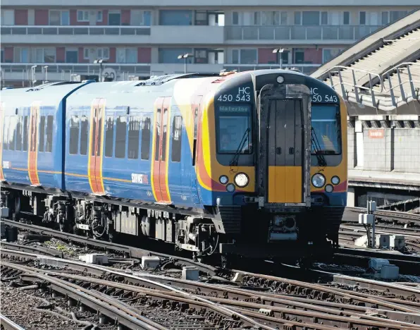  ?? JACK
BOSKETT/ RAIL. ?? Cost overruns on wiring the Great Western Main Line have diminished the economic case for replacing third rail. South West Trains 450543 approaches Waterloo on March 27 2012.