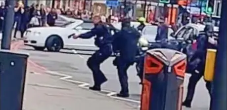  ??  ?? Brave: Officers move in on Amman, before backing away fast when they spot the canisters on his chest