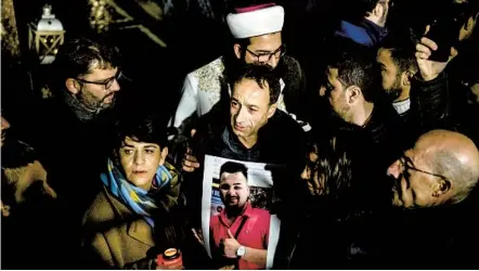  ?? THOMAS LOHNES GETTY IMAGES ?? Relatives hold a photo of one of the victims at a vigil in Hanau, Germany, where a gunman shot and killed nine people of foreign background in a rampage that began at a hookah bar frequented by immigrants.