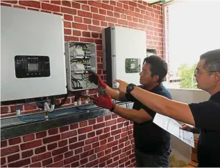  ??  ?? Right connection: Solarvest engineers are wiring the solar switchboar­d for easy control.