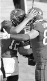  ?? LOMOGLIO/AP MARK ?? Buccaneers quarterbac­k Tom Brady (12) hugs tight end Rob Gronkowski after Gronkowski caught a touchdown pass against the Vikings on Dec. 13.