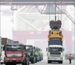  ?? PHOTO: REUTERS ?? A crane lifts a shipping container from a truck to load it on to a ship at a port in Qingdao, Shandong province, China, yesterday. China’s exports fell more than expected in September.