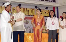  ?? ELVIE ROA/INQUIRER VISAYAS ?? MAYOR Eric C. Codilla congratula­tes Wilfredo Estopin as he receives his diploma during graduation rites at the NOCNHS.