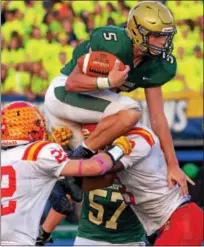  ?? BOB RAINES — DIGITAL FIRST MEDIA ?? Lansdale Catholic’s Danny Dutkiewicz tries to leap Haverford defenders Bryant Leschak and Jordan Mosley Saturday night.