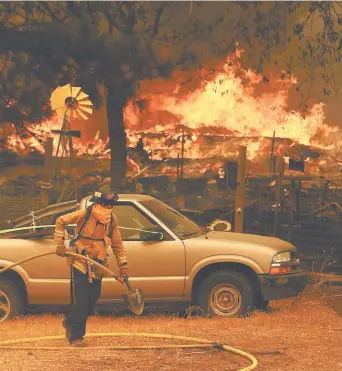 ??  ?? Un bombero trabaja para controlar el incendio Ranch en Spring Valley, California.