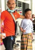  ??  ?? Arif Azril Mohd Yusuf, seen with his father, appears relieved after undergoing circumcisi­on.