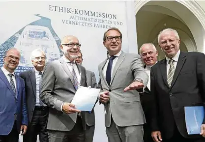  ??  ?? Bundesverk­ehrsminist­er Alexander Dobrindt (CSU, .von rechts) erhält den Bericht der Ethik-Kommission von deren Leiter Udo Di Fabio (Mitte). Foto: imago/Reiner Zensen