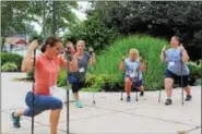  ?? MICHILEA PATTERSON — DIGITAL FIRST MEDIA ?? Lucie Bergeyova, far left, leads a seminar in Nordic Walking at the Pottstown Middle School. The group used the walking poles to do several stretches during the session.