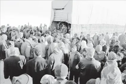  ?? IHH VIA ASSOCIATED PRESS ?? Syrians fleeing the conflict s in the Azaz region congregate at the Bab al-Salam border gate in Syria on Friday. Turkish of ficials say thousands of Syrians have massed at the border seeking refuge in Turkey. Of ficials said it was not clear when Turkey would open the border to allow the group in.