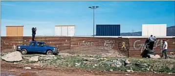  ?? GUILLERMO ARIAS/GETTY-AFP ?? Journalist­s get a glimpse from the Mexican side of the U.S.-Mexico border in Tijuana, across from border-wall prototypes.