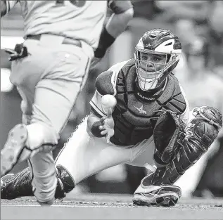  ??  ?? GETTY IMAGES Brewers catcher Martin Maldonado misses the ball at home plate, allowing the Diamondbac­ks’ Chris Owings to score during the second inning Saturday. The loss was the Brewers’ seventh in a row.