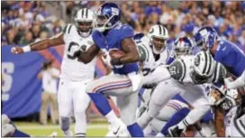  ?? THE ASSOCIATED PRESS ?? Giants’ Orleans Darkwa (26) runs past Jets’ Demario Davis (56) and others for a touchdown during the first half a preseason game Aug. 26 at MetLife Stadium.