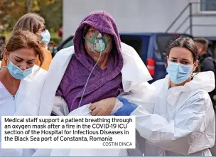  ?? COSTIN DINCA ?? Medical staff support a patient breathing through an oxygen mask after a fire in the COVID-19 ICU section of the Hospital for Infectious Diseases in the Black Sea port of Constanta, Romania