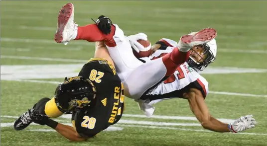  ?? PHOTOS BY CATHIE COWARD, THE HAMILTON SPECTATOR ?? Ticats’ Craig Butler takes down Ottawa’s Diontae Spencer in Friday’s game in Hamilton. The Ticats lost again, 37-18, falling to 0-8. For complete coverage, see Drew Edwards’ story at thespec.com.