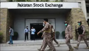  ?? (AFP) ?? Paramilita­ry officers inspect the premisses of the Pakistan Stock Exchange building following an attack by gunmen in Karachi on Monday.