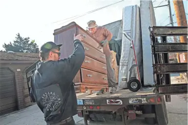  ?? MICHAEL SEARS / MILWAUKEE JOURNAL SENTINEL ?? Chris Jaszewski (right) and Brian Traut of Casa Maria load furniture stored in garages at Casa Maria onto a truck for delivery. Casa Maria picks up donated furniture to provide to people who have just left its homeless shelters for a permanent residence.