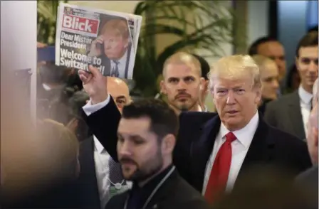  ?? LAURENT GILLIERON — KEYSTONE VIA AP ?? President Donald Trump holds up Swiss newspaper ‘Blick’ as he arrives at the Congress Center on the last day of the annual meeting of the World Economic Forum, WEF, in Davos, Switzerlan­d, Friday.