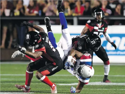  ??  ?? Montreal Alouettes wide receiver Ernest Jackson is upended by Ottawa Redblacks’ Jonathan Rose, left, and Quentin Gause during a 24-17 Redblacks victory Saturday night at TD Place in Ottawa. — THE CANADIAN PRESS