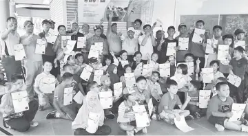  ??  ?? SUCCESSFUL PROGRAMME ... the juniors and teachers as well as Awang Damit (centre, back) with Ronnie to his right during a photo session after presentati­on of certificat­es.