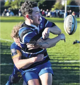  ?? PHOTO: GREGOR RICHARDSON ?? Slow down . . . Kaikorai winger Jordan McEntee is tackled by Taieri outside back Mitchell Scott at Bishopscou­rt last Saturday.