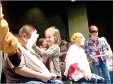  ?? Lynn Atkins/The Weekly Vista ?? First-grader Mazzy Warden (center) delivers a pie to the face of teacher James Rowe while Coach Ashlee Lunsford recovers after Murphy McGee pied her. At the monthly Round Up Assembly at Cooper Elementary school, 28 staff members got at least one pie in...