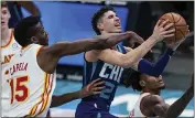  ?? JACOB KUPFERMAN — THE ASSOCIATED PRESS ?? The Hawks’ Clint Capela (15) fouls the Hornets’ LaMelo Ball (2) during the second half Saturday in Charlotte, N.C.