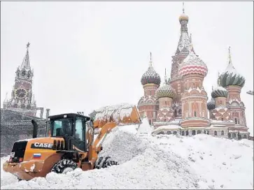  ?? Vasily Maximov AFP/Getty Images ?? WORKERS clear snow from Red Square. The army was called in to help city crews in the Russian capital.