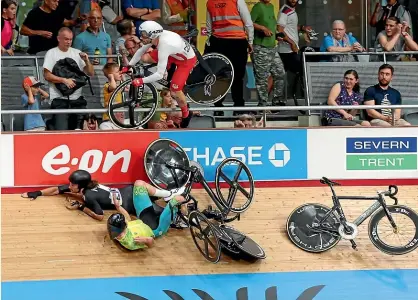  ?? AP ?? New Zealand rider George Jackson escaped this crash on the velodrome in qualifying to help teammate Corbin Strong claim gold in the 15km scratch race final yesterday. England’s Matt Walls is airborne.