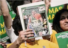  ?? ?? A George Mason University fan holds up the cover of Sports Illustrate­d magazine at a send off for the team in 2006. Much of the staff of Sports Illustrate­d, and possibly all remaining writers and editors, received layoff notices Friday, which could spell the end of a publicatio­n that for decades was the gold standard of sports journalism.