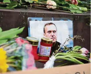  ?? Foto: Christoph Schmidt/dpa ?? Nach dem Tod von Alexej Nawalny liegen bei einer Andacht Blumen, Kerzen und Schriftzüg­e am Stuttgarte­r Schillerpl­atz.