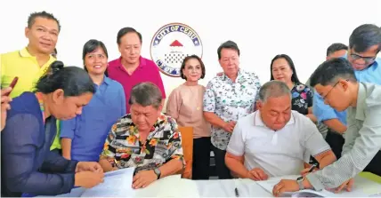  ??  ?? Cebu City Mayor Tomas Osmeña and Cebu Gov. Hilario Davide III sign the deeds of donations for the land swapping.