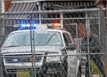  ?? TRENTONIAN - FILE PHOTO ?? Law enforcemen­t examines a police vehicle on Wilson Street that was shot by a suspect during a 2014 shootout that left the man dead.