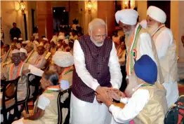  ?? —G.N. JHA ?? Prime Minister Narendra Modi greet freedom fighters during a reception organised at the Rashtrapat­i Bhawan in New Delhi on Wednesday.