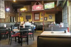  ?? Arkansas Democrat-Gazette/ERIC E. HARRISON ?? The front dining room at the newly renovated Shorty Small’s features booth and table seating, two large flat-screen TVs and shack-like wood paneling.